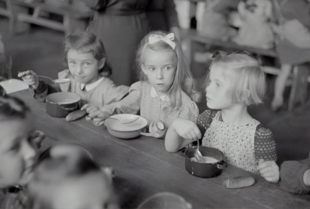 Girls eating porridge together.  Mealtime is a great time to work on phonemic awareness skills to boost early literacy.