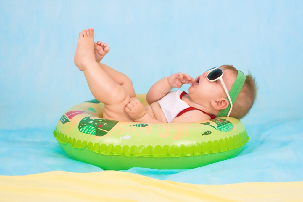 A little baby pretending to float in water in a floating ring.  Akin to parents relaxing and learning how to interact with their little tot.