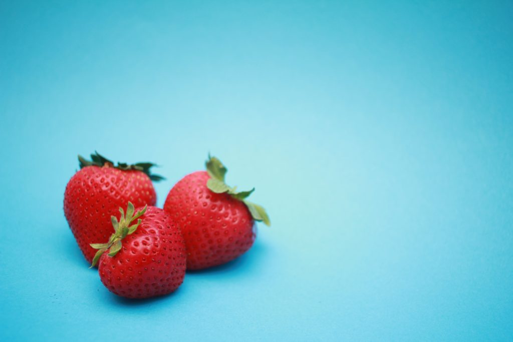 Picture of three strawberries.  Challenge children to describe a strawberry in order to improve their descriptive language skills.